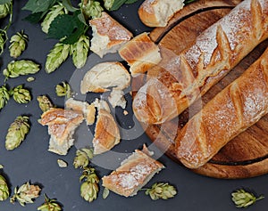 Fresh organic homemade bread from hop sourdough on black stone background. Natural french baguette. Rural kitchen or bakery