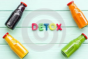 Fresh organic juices in bottles for detox diet on green wooden background top view mock-up