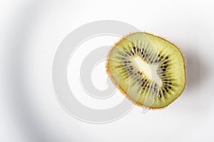 Fresh organic kiwi fruits on white plate for healthy breakfast or dinner. Copy space. Dietary vegetarian food. Top view