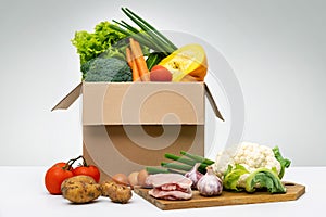 Fresh organic local farm food - group of vegetables eggs and meat in cardboard box