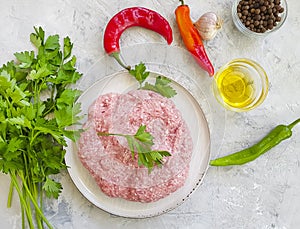 Fresh organic minced meat on a plate on a concrete background