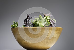 Fresh organic mix of green salad in a wooden bowl. Healthy concept.