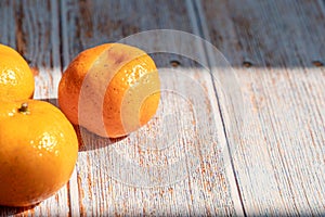 Fresh organic orange fruit on wooden background with light sunshine shadow and copy space