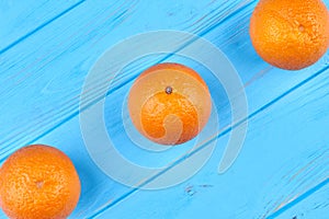 Fresh organic orange fruits on blue background.