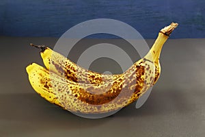  fresh organic over ripe dark brown spots yellow banana fruit on dark background