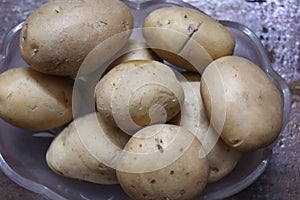 Fresh Organic Potatoes isolated on wood background