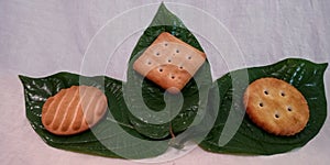 Fresh organic produce fruit flavor biscuits  on green leaves at white background