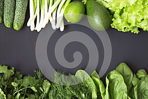 Fresh organic raw produce. Green toned vegetables and fruits on dark background.