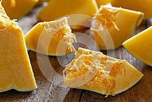 Fresh organic raw sliced pumpkin on wooden background, selective focus, close up