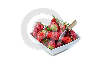 Fresh organic red strawberries in a ceramic bowl on white background