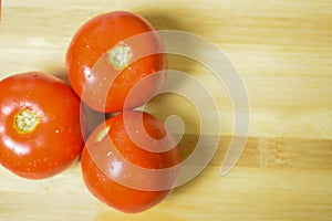 Fresh Organic Red Tomotoes isolated on Wooden Chopper Board