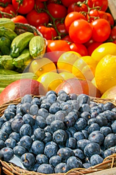 Fresh organic ripe blueberries in a basket and various fruits and vegetables