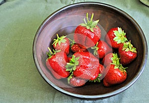 Fresh organic ripe fruits strawberry berries natural gourmet product brown ceramic plate background
