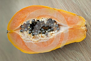 Fresh organic ripe papaya fruit cut in half on a wooden board. Exotic fruits, healthy eating concept