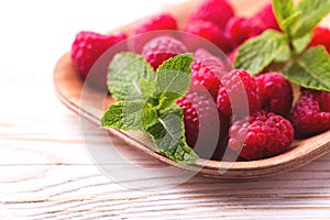 Fresh organic ripe raspberry with mint leaves in tray