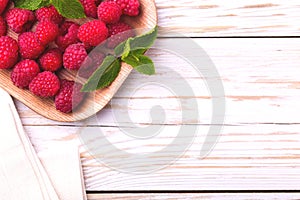 Fresh organic ripe raspberry with mint leaves in tray