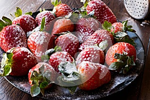 Fresh Organic Ripe Strawberries with Powdered Sugar on Black Plate.