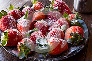 Fresh Organic Ripe Strawberries with Powdered Sugar on Black Plate.