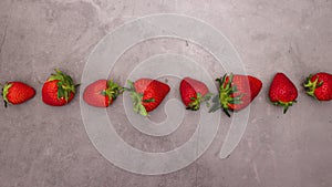 Fresh and organic strawberries rolling on dark background - Stop motion