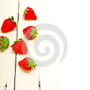 Fresh organic strawberry over white wood