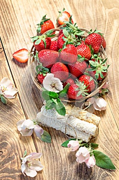 Fresh organic strawberry in wicker basket on rustic table