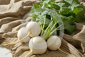 Fresh organic turnips with green leaves on a rustic burlap cloth.