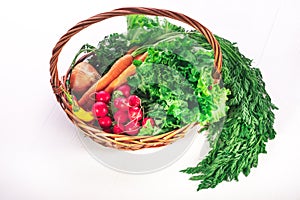 Fresh organic vegetables in basket on wooden table. Homegrown healthy food from farm on white background