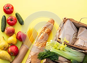 Fresh organic vegetables, greens and fruits on a yellow background. Ecological farm food concept. Top view. Flat lay
