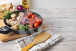 Fresh organic vegetables, tomatoes, mushrooms, peppers and thyme in frying pan