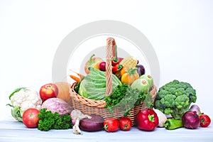 Fresh organic vegetables in wicker basket isolated