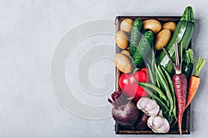 Fresh organic vegetables in a wooden box, top view with copy space