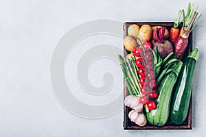 Fresh organic vegetables in a wooden box, top view with copy space