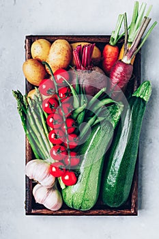 Fresh organic vegetables in a wooden box, top view with copy space