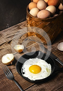 Fresh organic village eggs on wooden table, healthy food,  village food. black pan with fried egg. fresh onion