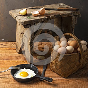 Fresh organic village eggs on wooden table, healthy food,  village food. black pan with fried egg. small bench background