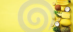 Fresh organic yellow fruits over sunny background. Monochrome concept with banana, coconut, pineapple, lemon, melon. Top