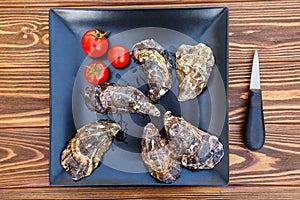 Fresh oysters on a black plate