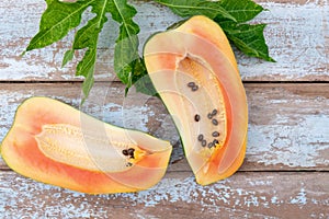 Fresh papaya fruit cut in half on wooden background