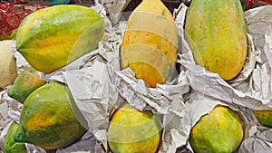 Fresh papaya or pawpaw on display at a market with a focus on their textured green skin selling local fruit market