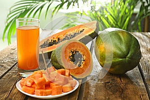 Fresh papayas and juice on wooden table