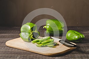 Fresh paprika cut on a wooden board/fresh paprika cut on a wooden board on a dark background, selective focus