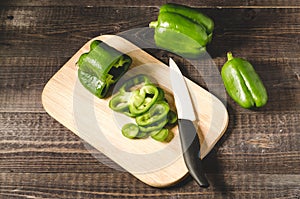 fresh paprika cut on a wooden board/ fresh paprika cut on a wooden board on a dark background, top view