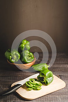 fresh paprika in a wooden bowl and cut on a board/fresh paprika in a wooden bowl and cut on a board on a dark background with copy