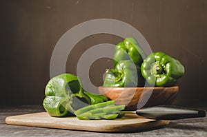 fresh paprika in a wooden bowl and cut on a board/fresh paprika in a wooden bowl and cut on a board on a dark table, selective