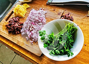 Fresh parsley in a dish and chopped food ingredients prepared for cooking