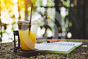 Fresh passion fruit juice in glass on table with is tree garden background