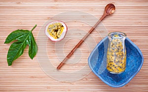 Fresh passion fruits juice in bottle on bamboo background. Juic