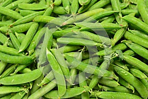 Fresh pea pods as background. Top view