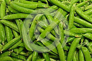 Fresh pea pods as background. Top view