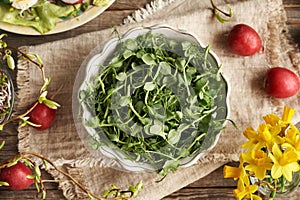 Fresh pea sprouts or microgreens in a white bowl, top view